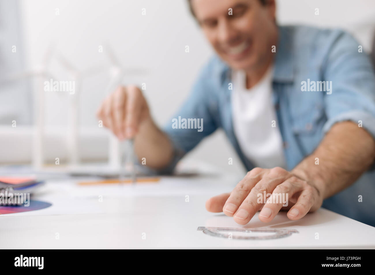 Positive smiling engineer working on the blueprint Stock Photo - Alamy