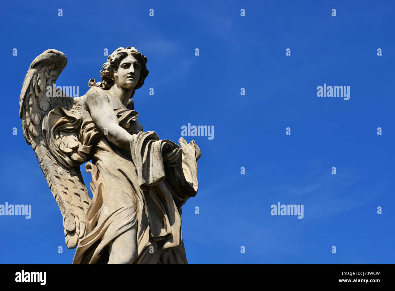 Angel marble statue with garment and dice, a 17th century baroque masterpiece on Holy Angel Bridge in Rome (with blue sky and copy space) Stock Photo