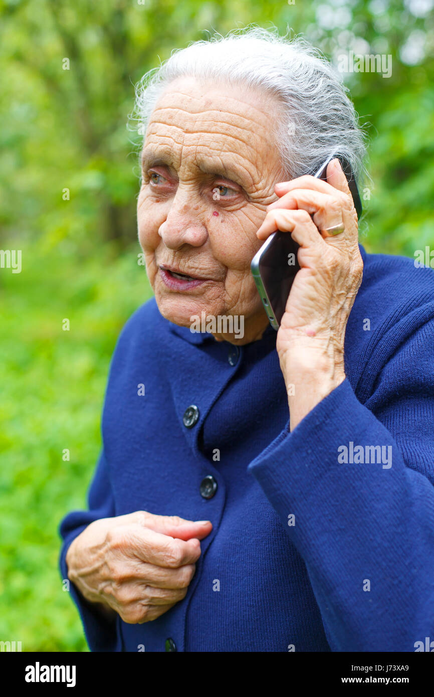 Portrait of a senior woman while talking on the phone Stock Photo - Alamy