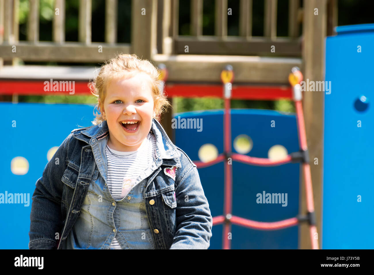 Happy little girl at playground Stock Photo - Alamy