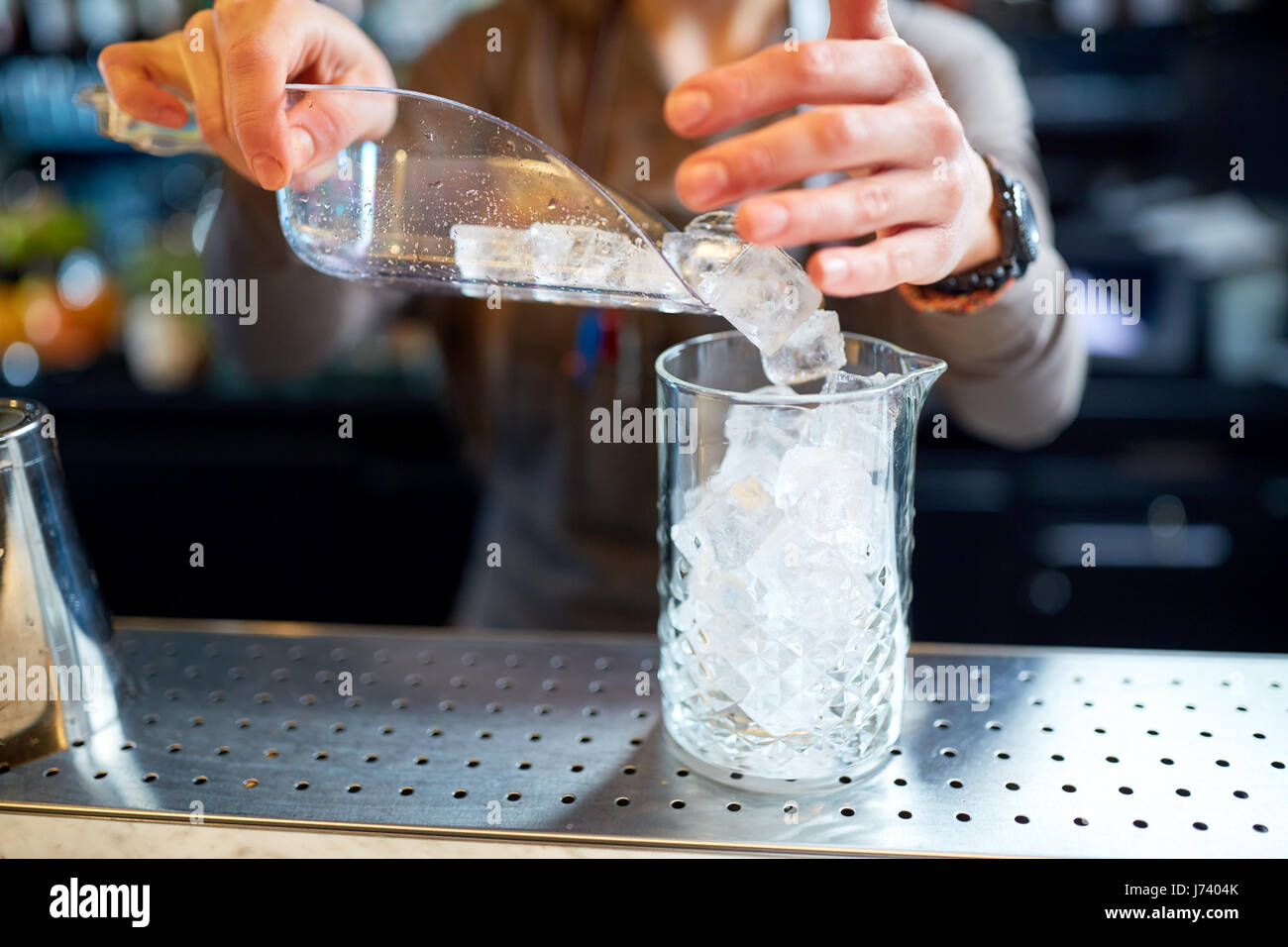 bartender pouring ice into glass jug at bar Stock Photo Alamy