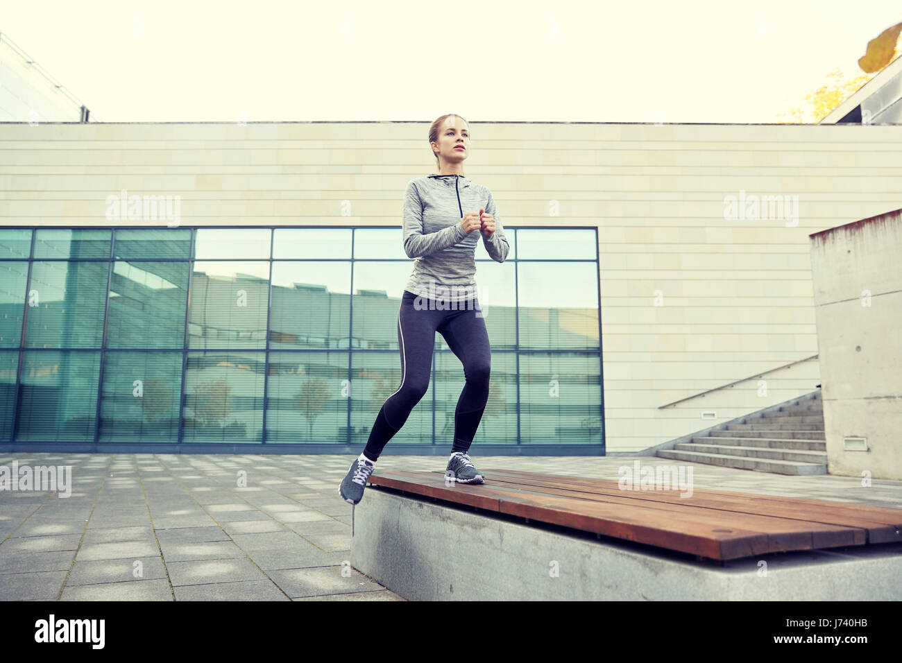 woman making step exercise on city street bench Stock Photo Alamy