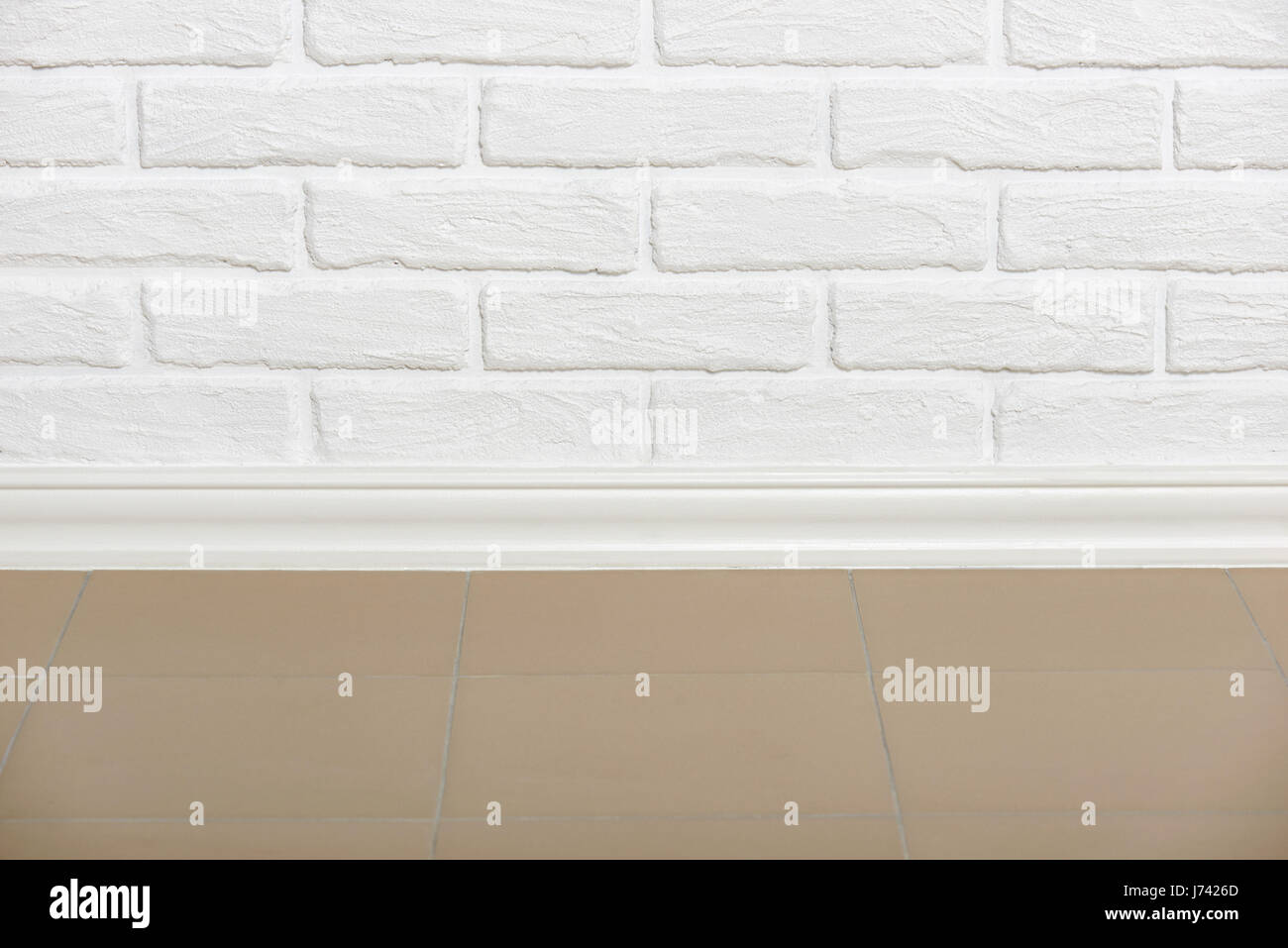 white brick wall with tiled floor closeup photo, abstract background ...