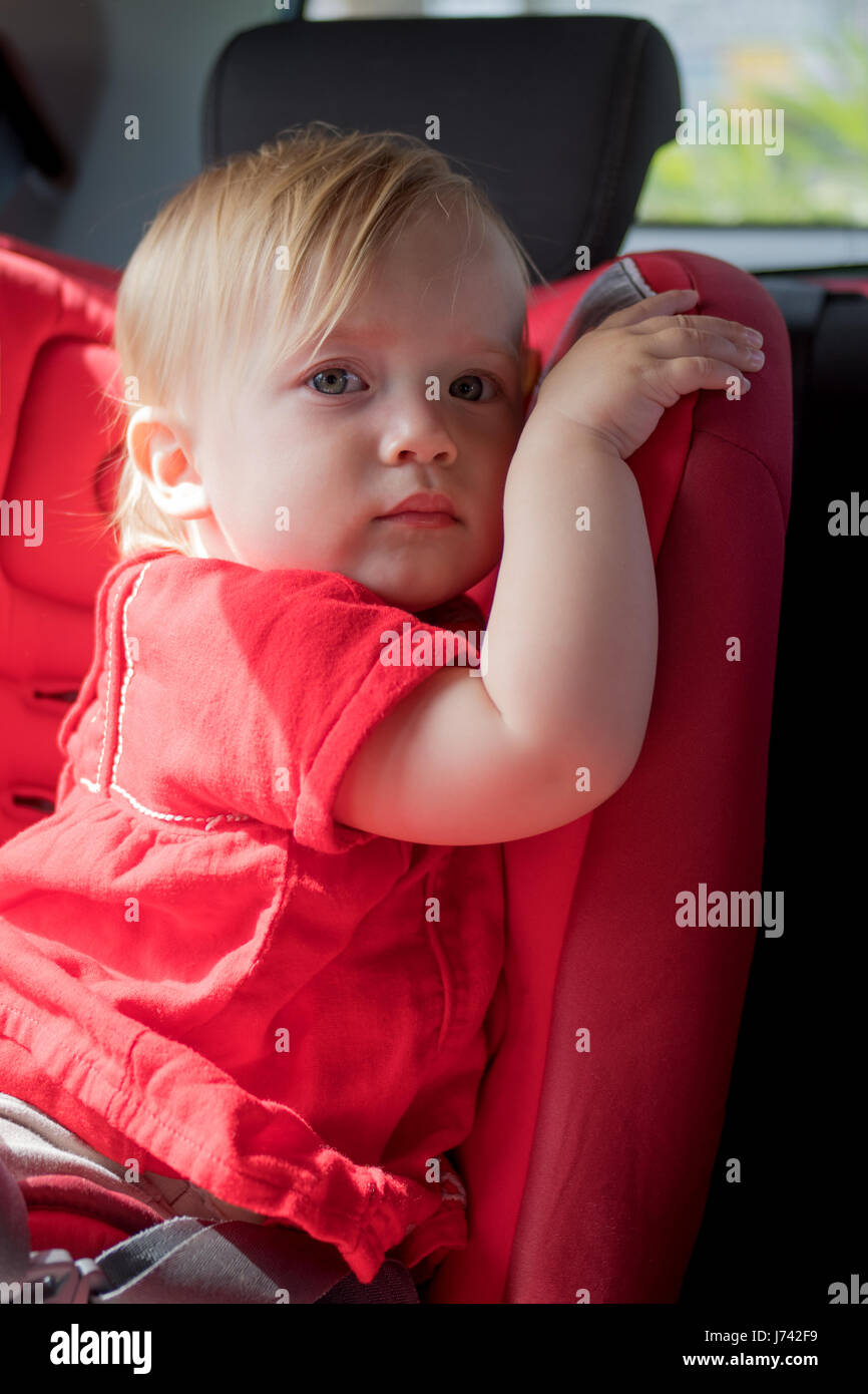 Little girl sitting in baby car safety seat Stock Photo