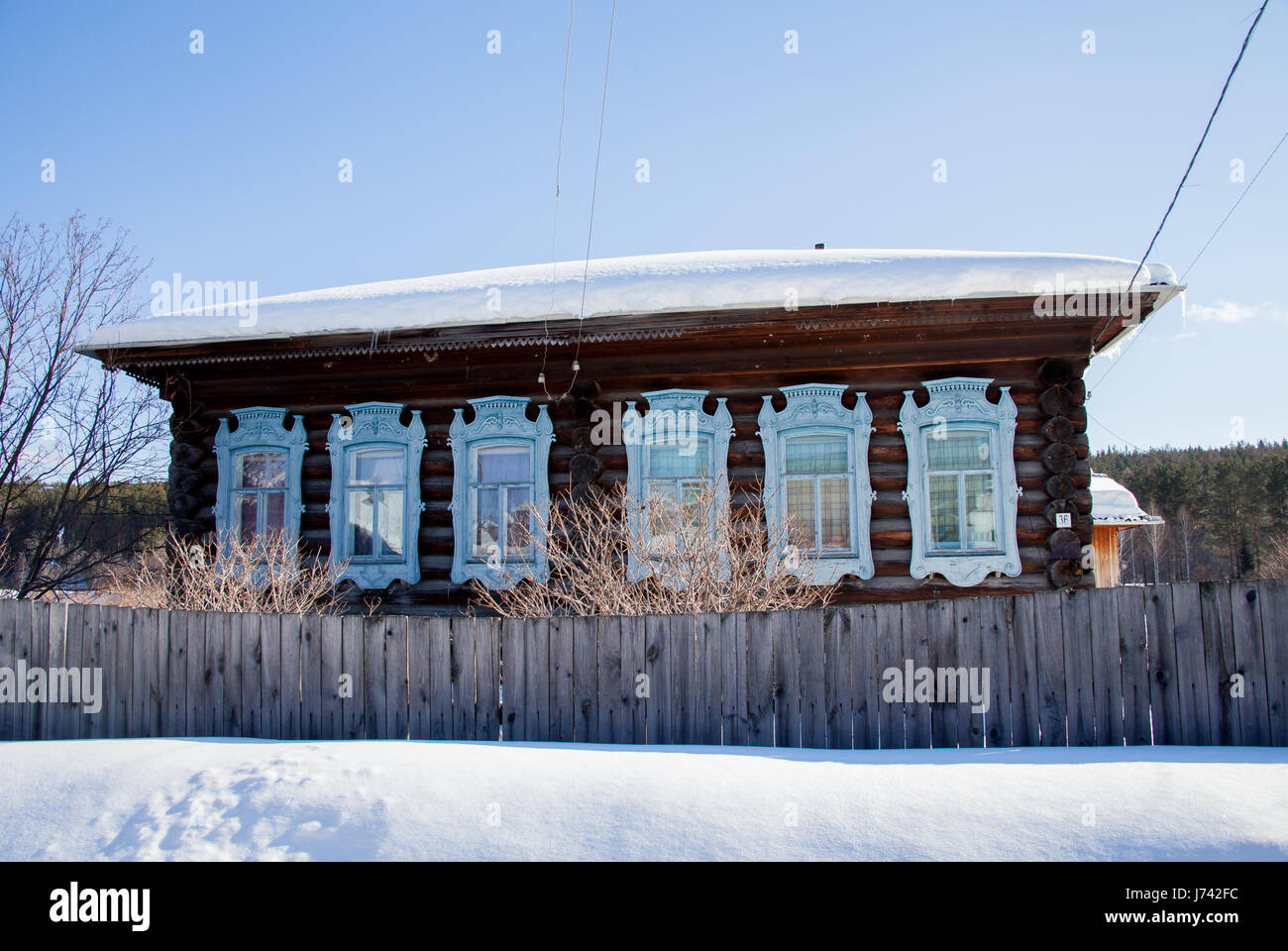 Wooden house in the village winter sunny day, Sverdlovsk region, Russia Stock Photo