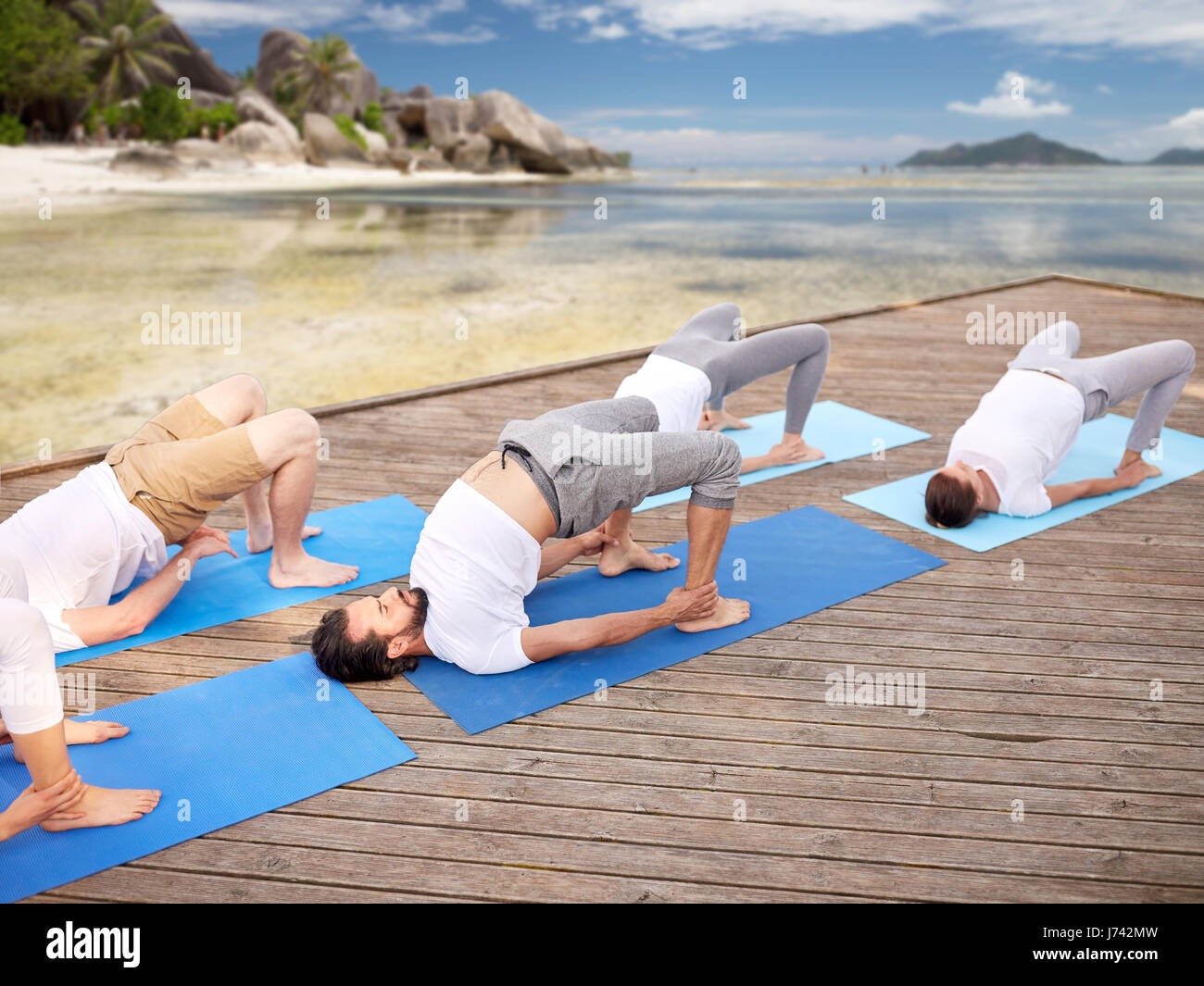 group of people making yoga exercises outdoors Stock Photo