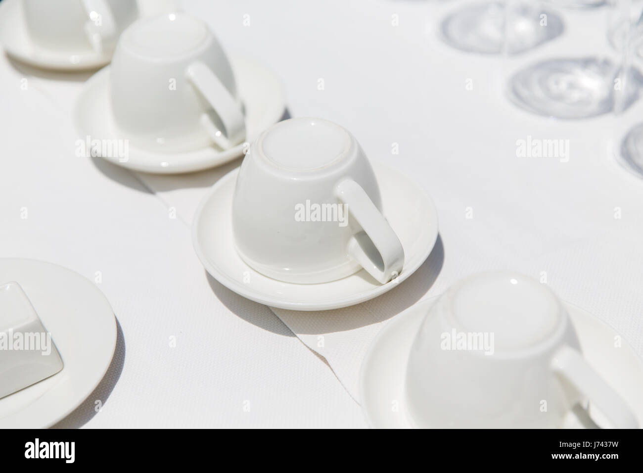 white coffee cups upside down on saucers Stock Photo