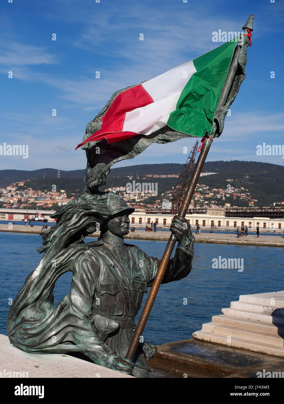 The italian flag on the statue of a bersagliere (anniversary of the liberation of Trieste). Stock Photo