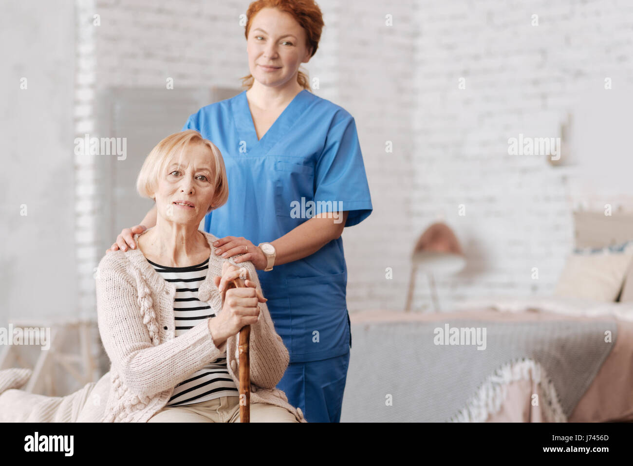 Qualified private nurse assisting elderly patient Stock Photo