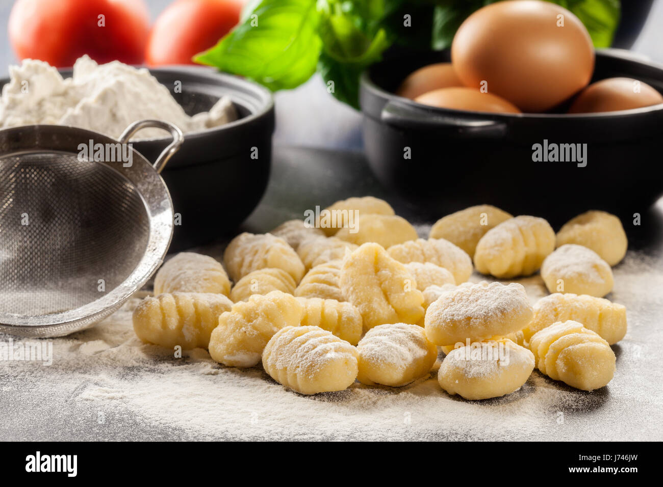 Uncooked homemade gnocchi on black cutting board Stock Photo