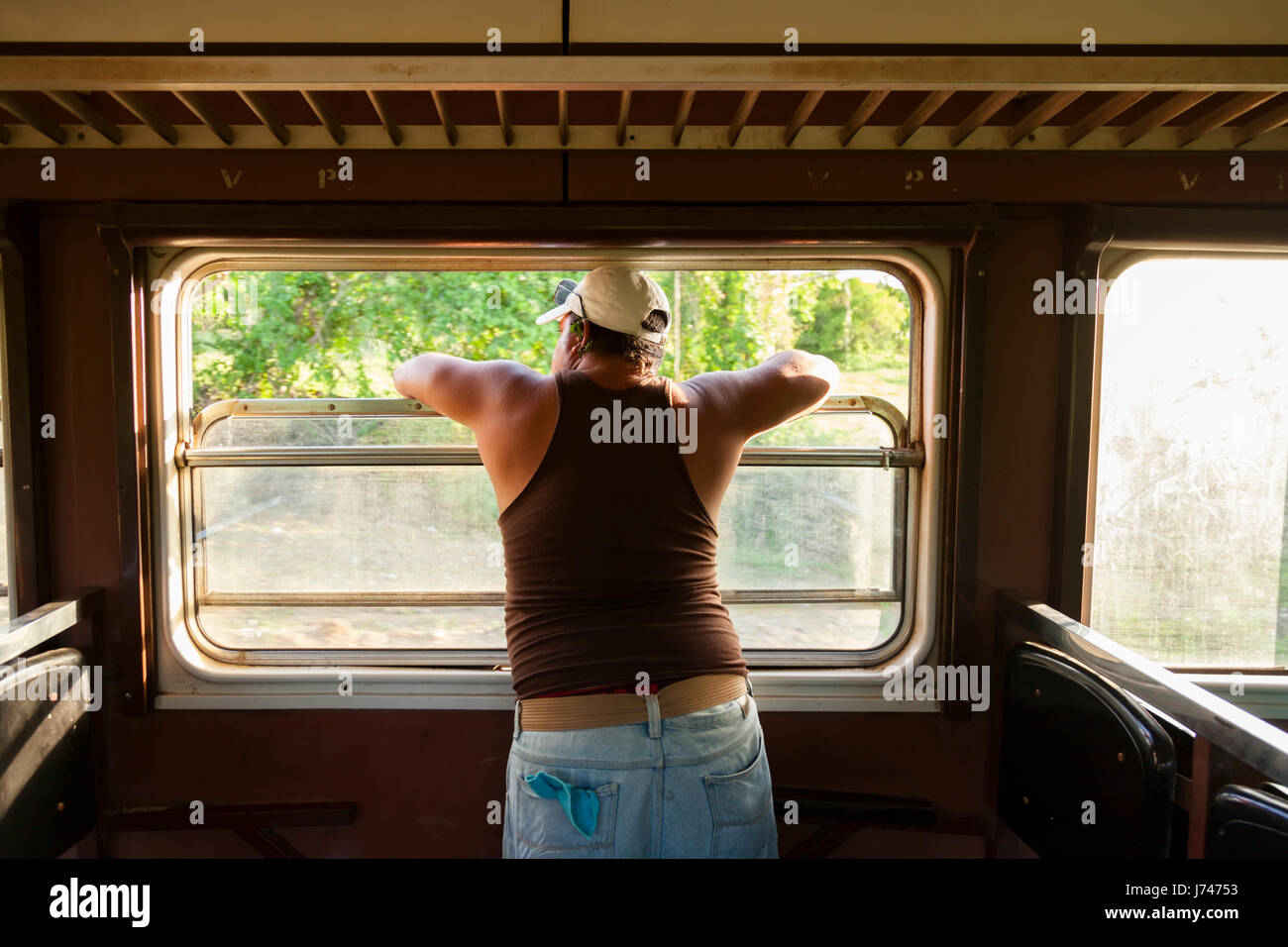 A man looking out a train window in Cuba. Stock Photo