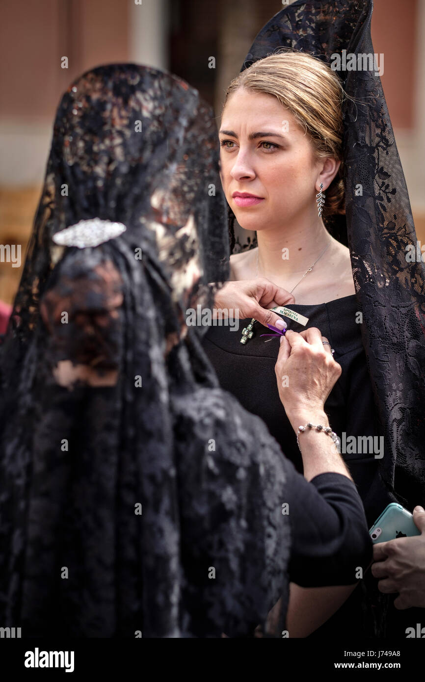 In Seville, during what is known as 'Jueves Santo' or Holy Thursday is very typical for women to dress in black with the traditional attire. Stock Photo