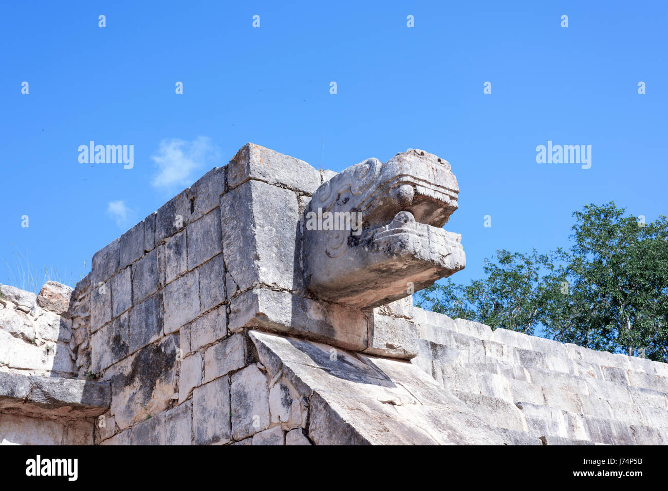 upward view of the stone jaguar head statue at the Platform of the Eagles and Jaguars in Mayan Ruins of Chichen Itza, Mexico Stock Photo