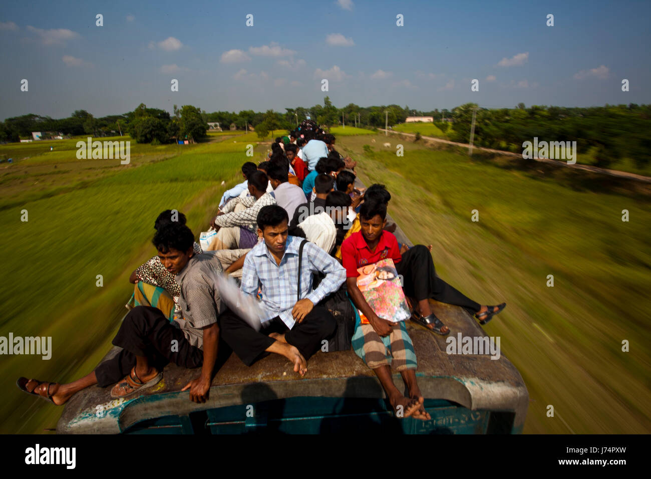 Thousands of Eid vacationers ride on top of train to reach their villages. Gazipur, Bangladesh Stock Photo