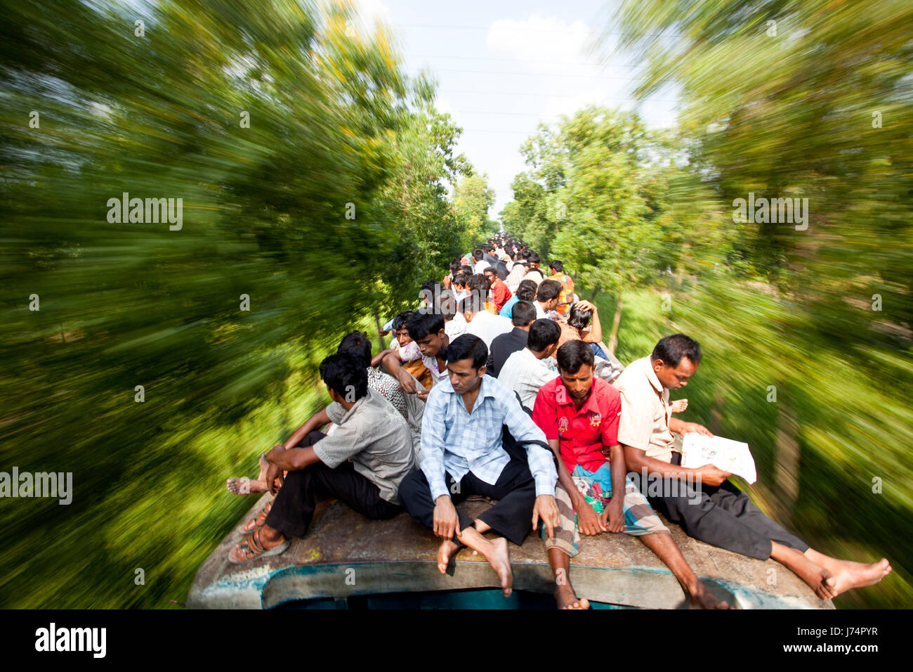 Thousands of Eid vacationers ride on top of train to reach their villages. Gazipur, Bangladesh Stock Photo