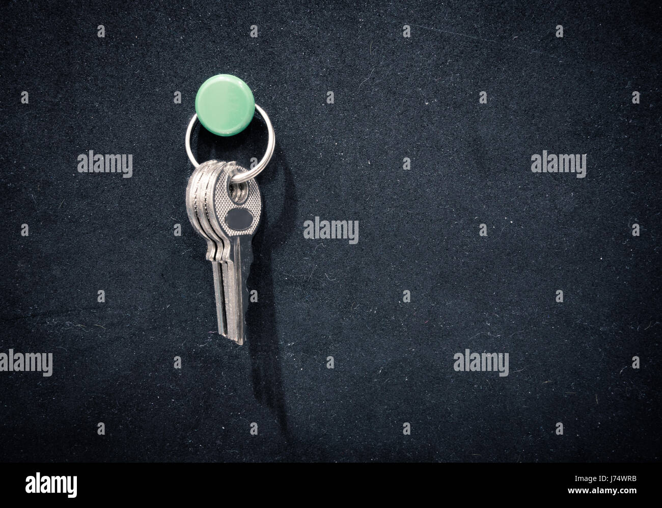 Keys pin on black rubber board. Stock Photo
