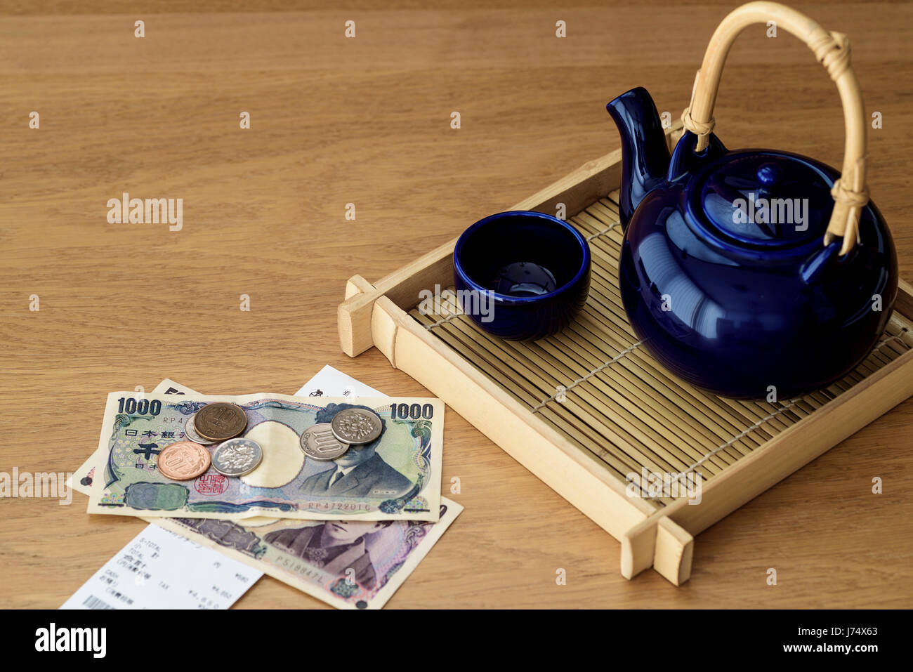 Japanese tea pot on bamboo tray with Yen and restaurant bill. Stock Photo