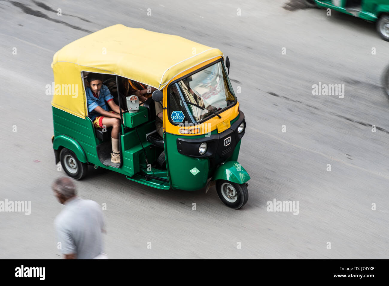 A speeding rickshaw  with passengers on a street in Bangalore,India. Stock Photo