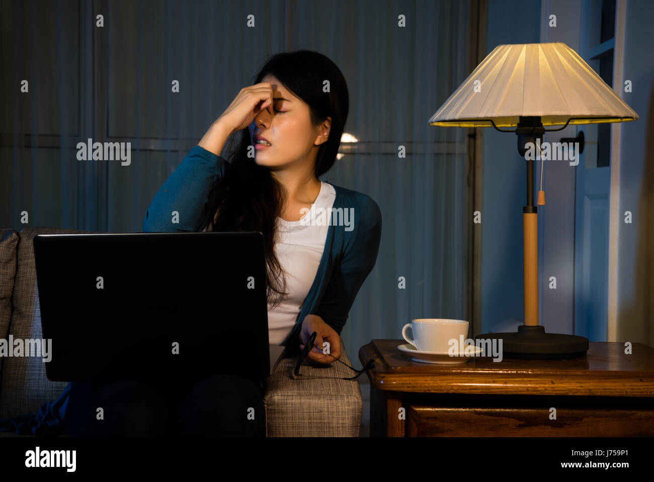 beautiful business girl having high intraocular pressure at night while working in free clothing at comfortable office massaging eyes relieving stress Stock Photo