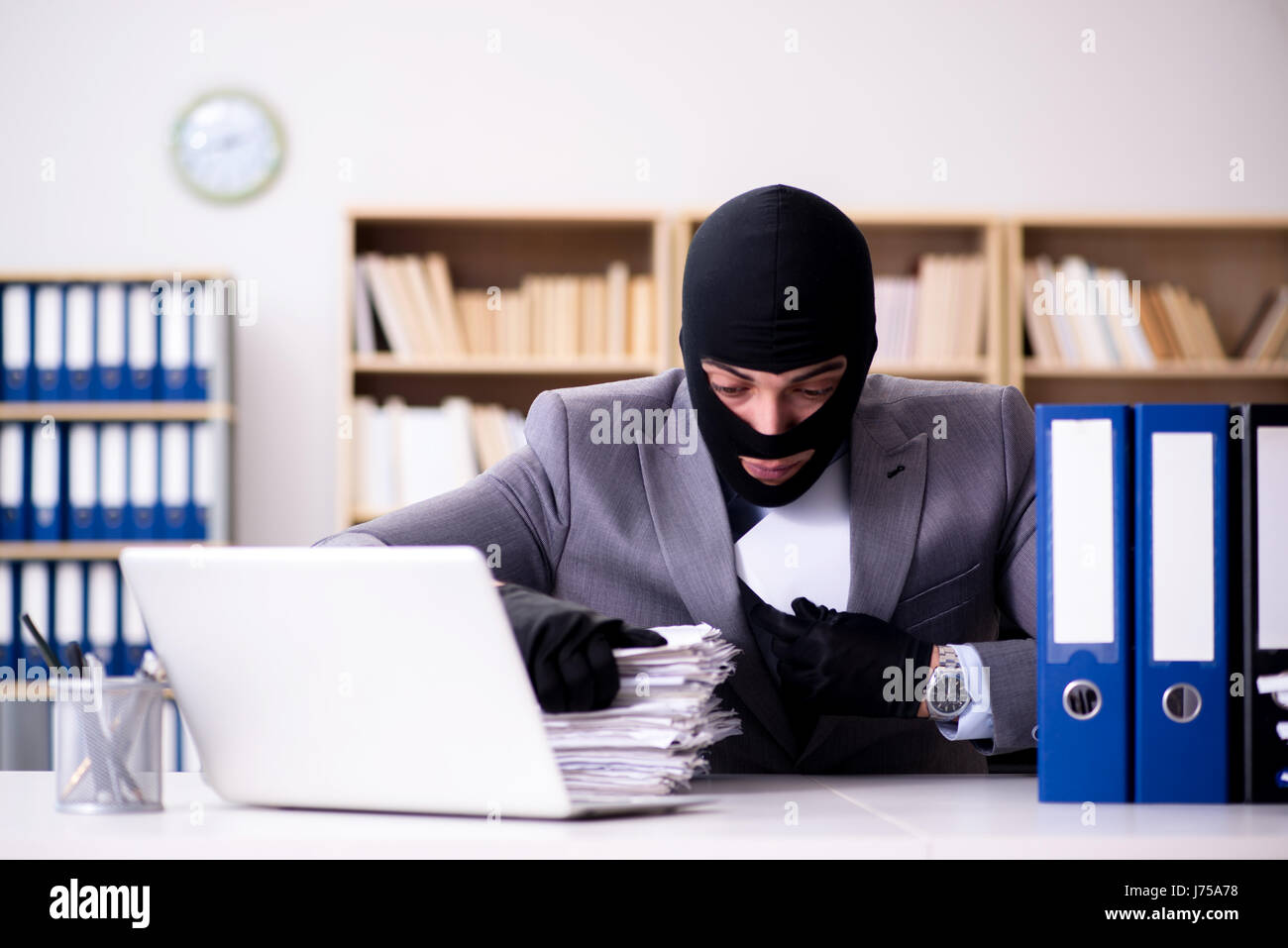 Criminal businessman wearing balaclava in office Stock Photo Alamy