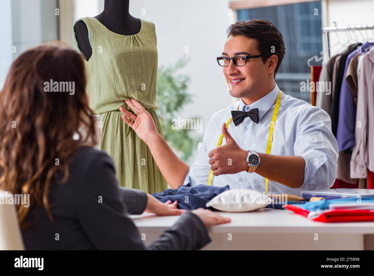 Young man tailor working with female client Stock Photo - Alamy