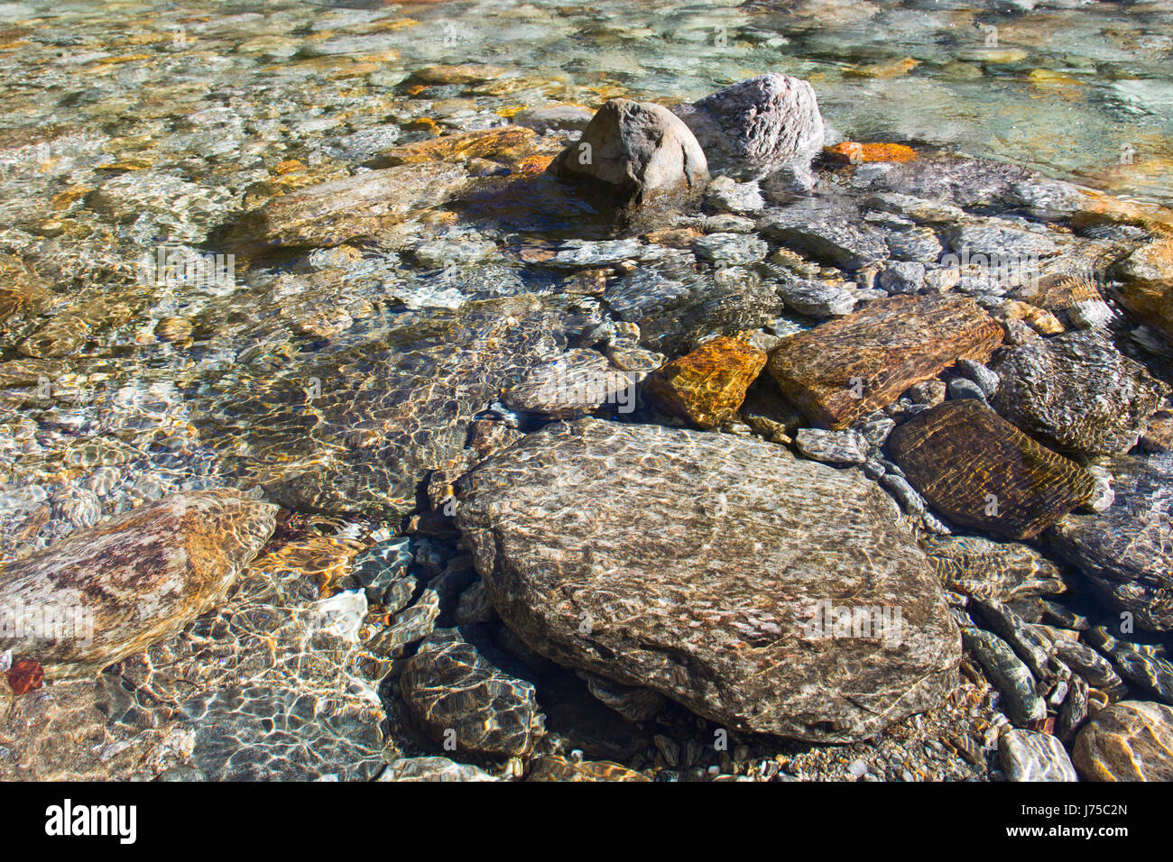 crystal clear water and colorful stones of natural wild swiss river verzasca Stock Photo