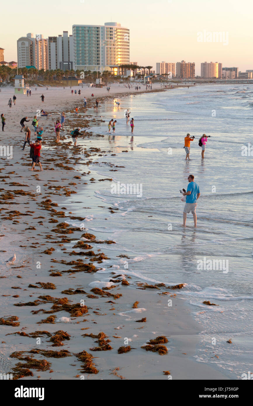 Clearwater, Florida - January 24, 2017: Late afternoon at Clearwater Beach as people wander and wade in the warm Gulf of Mexico waters among colorful  Stock Photo