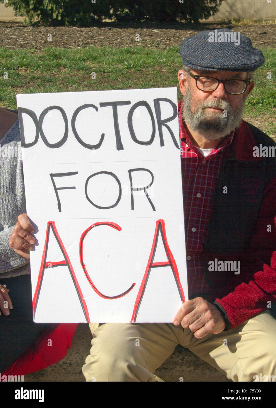 Asheville, North Carolina, USA - February 25, 2017:  An older man holds a sign at an Affordable Care Act rally that says ' DOCTOR FOR ACA' in oppositi Stock Photo