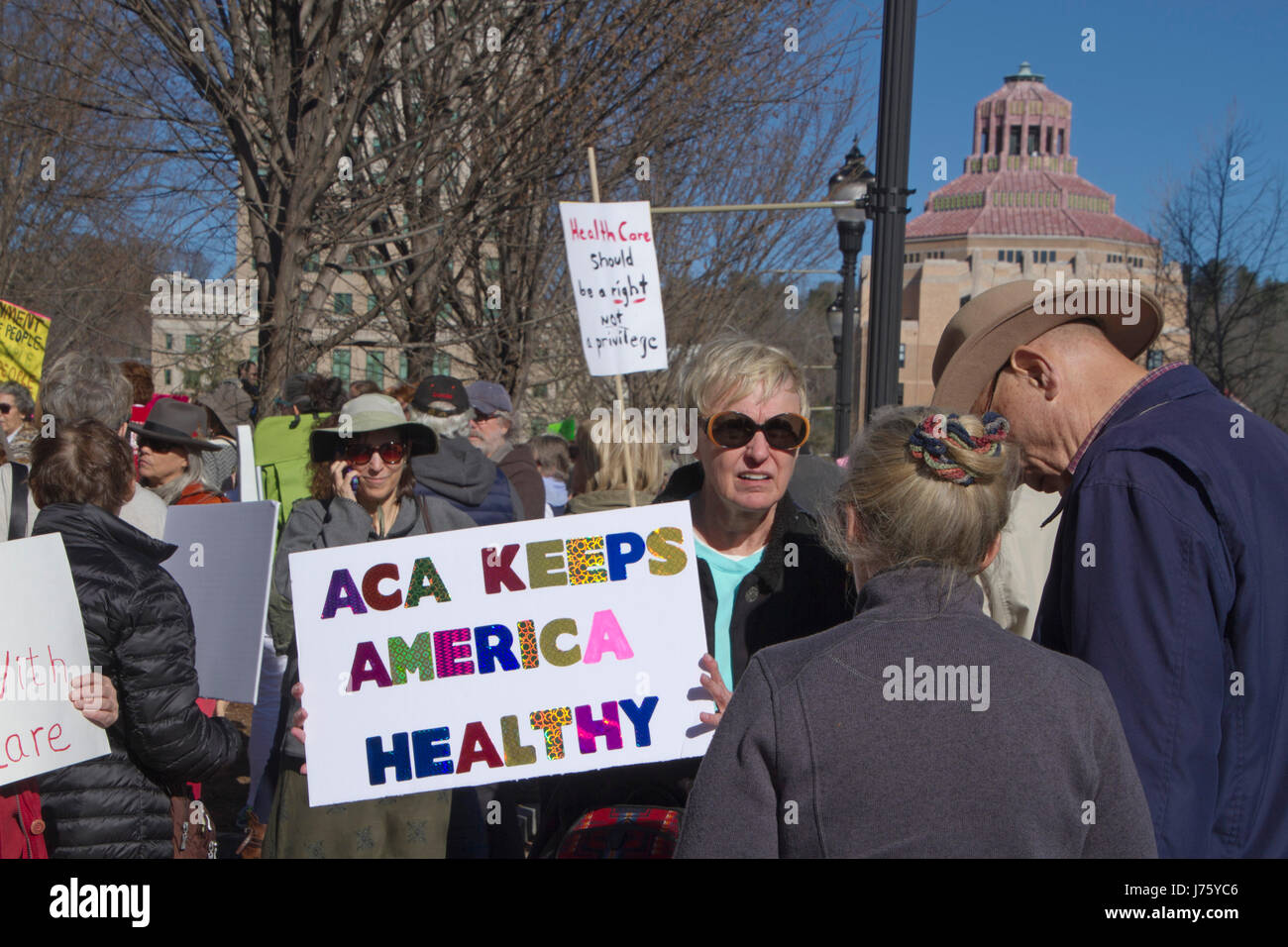 Asheville, North Carolina, USA - February 25, 2017:  A woman holds a sign at a crowded Affordable Care Act demonstration that says 'The ACA Keeps Amer Stock Photo