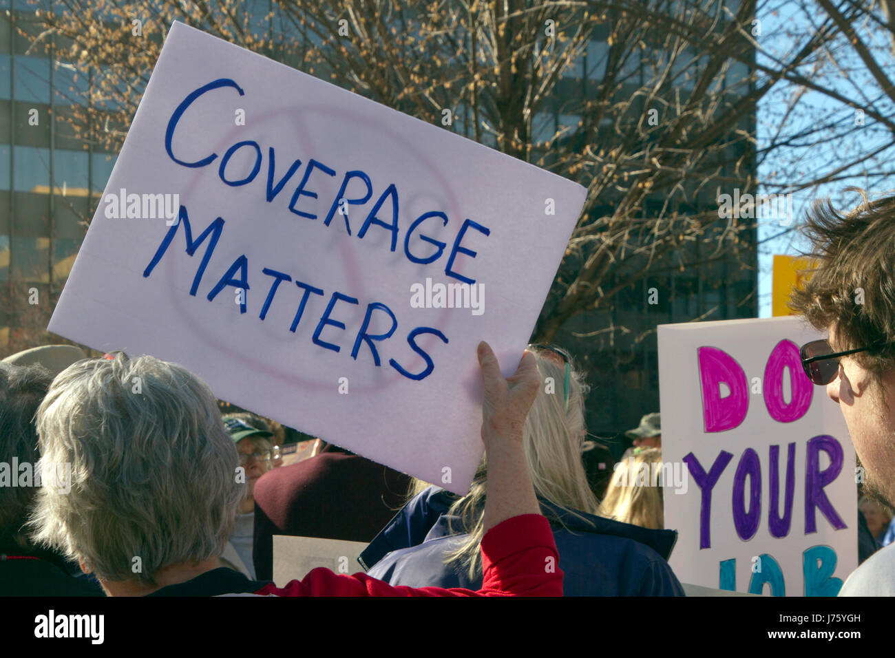 Asheville, North Carolina, USA - February 25, 2017:  Protesters hold signs at an Affordable Care Act rally saying that coverage matters as Republicans Stock Photo