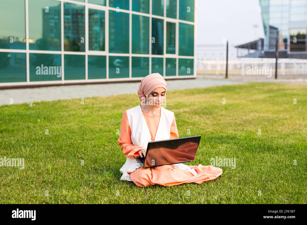 A young muslim woman using laptop outdoors Stock Photo - Alamy