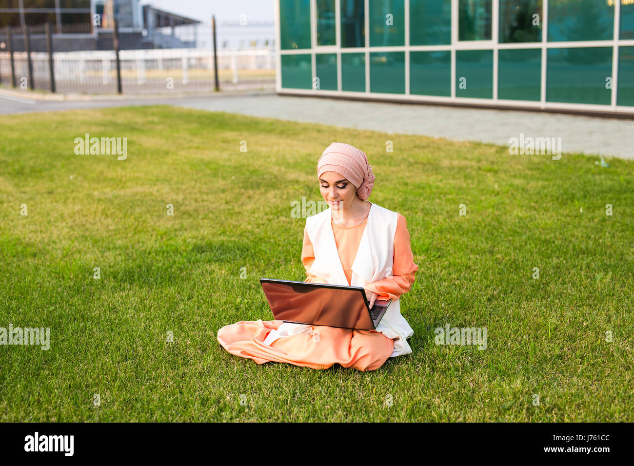 A young muslim woman using laptop outdoors Stock Photo - Alamy
