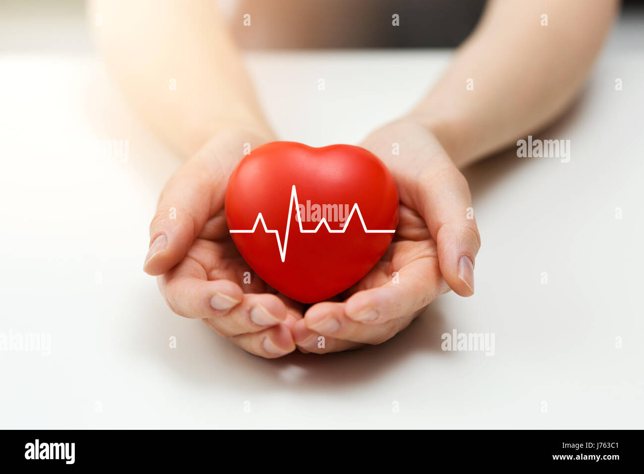 cardiology or health insurance concept - red heart in hands Stock Photo