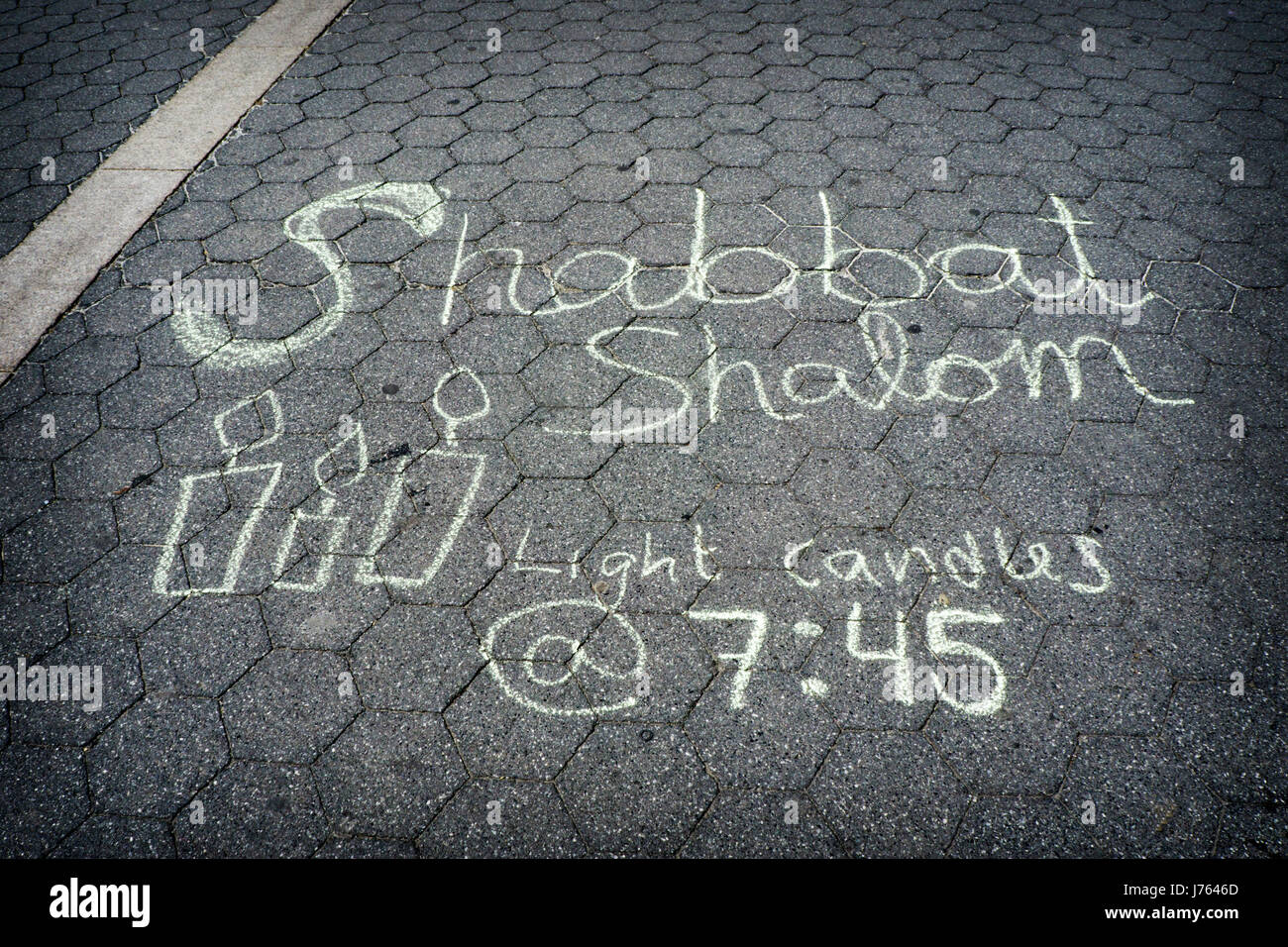 A chalk message in Union Square Park in Manhattan telling Jewish women passersby when to light Sabbath candles. Stock Photo