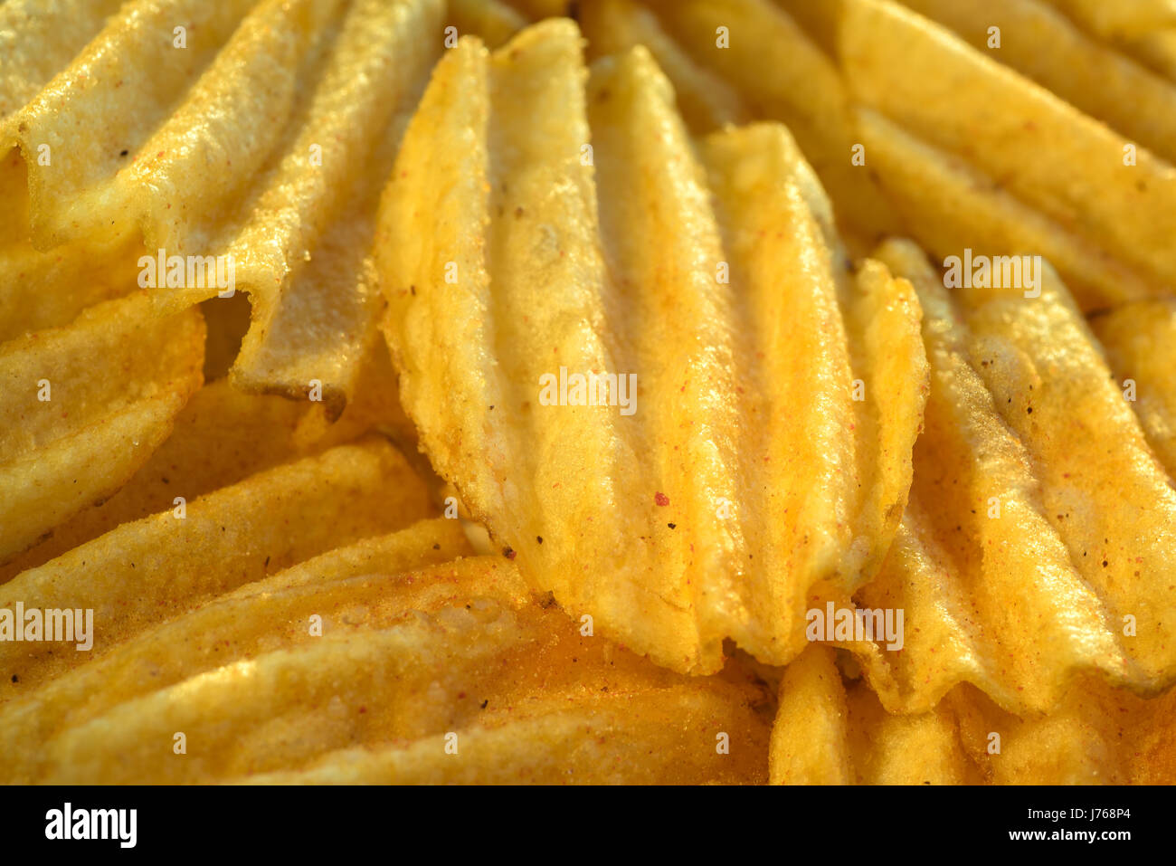Chips pattern. Yellow salted potato chips as background. Chips texture studio photo. Stock Photo