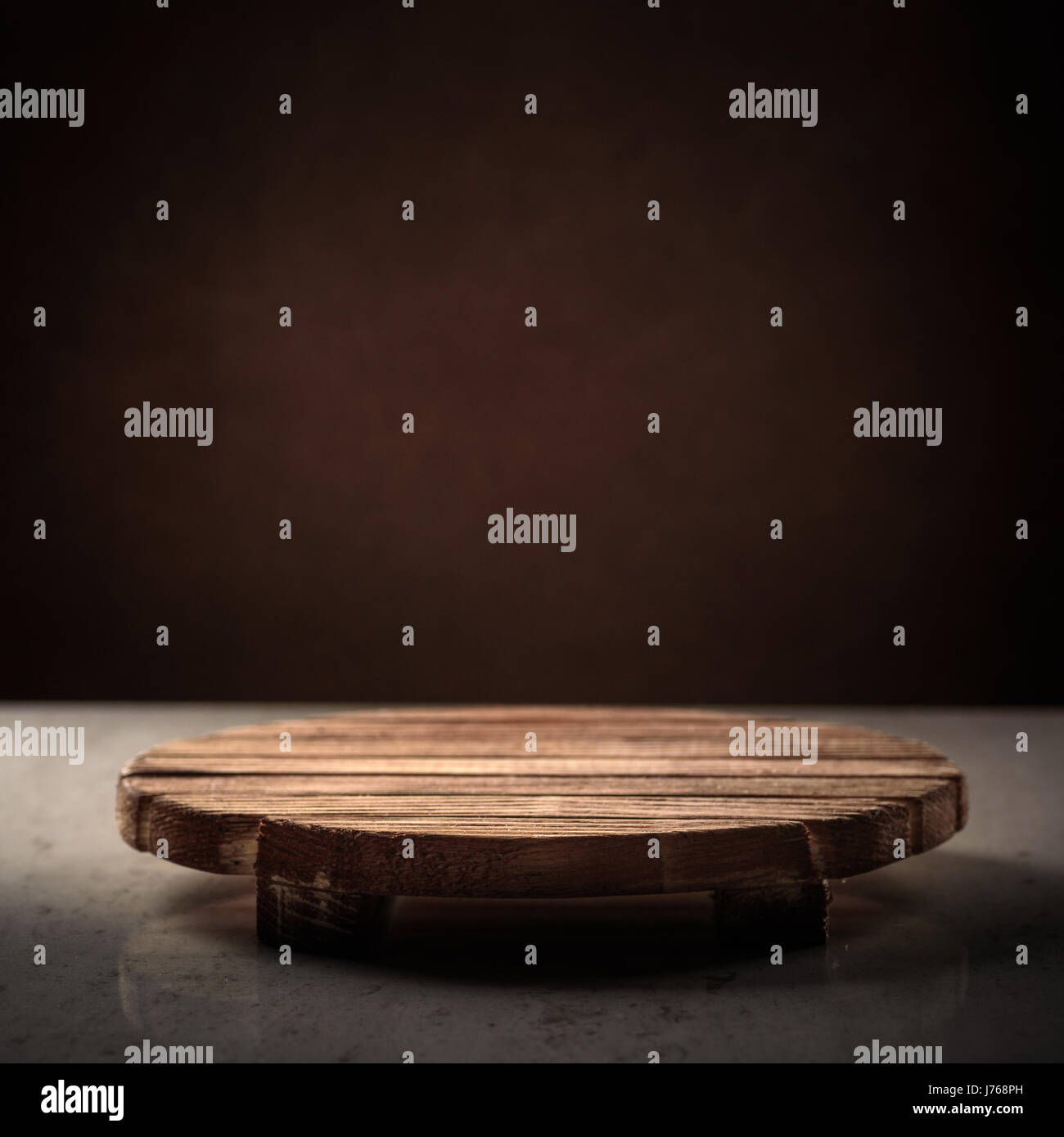 Wooden round stand for the bitterness of food on a dark background, place for inscription, cover Stock Photo