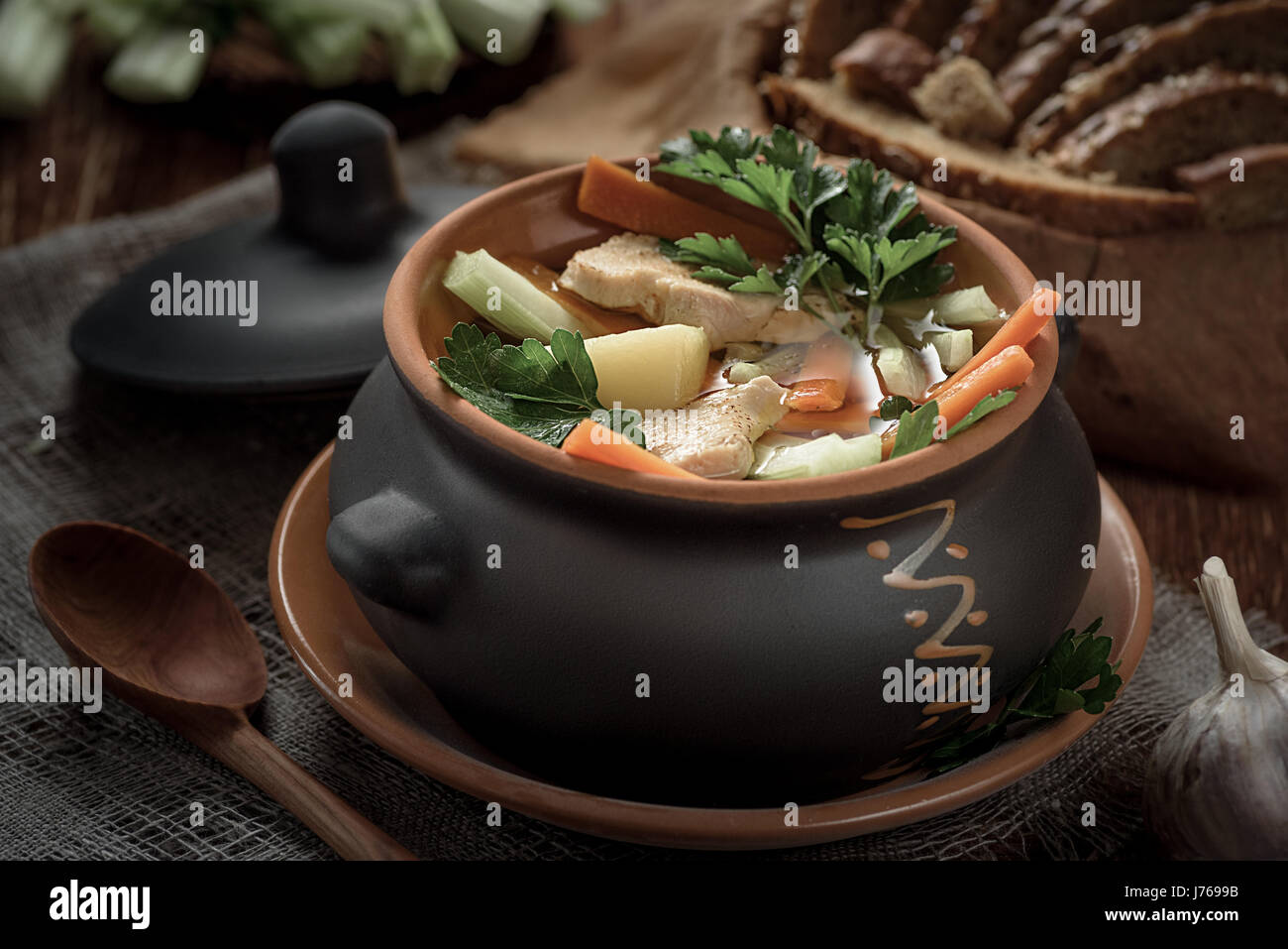 soup in the pot, bread, wooden spoon on the table closeup Stock Photo