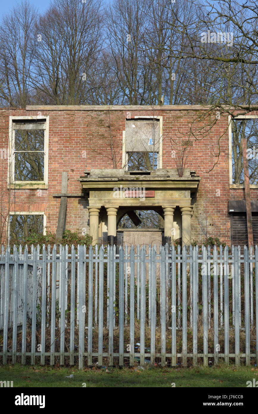 Whitefield town hall ruin behind galvanized steel security fencing in