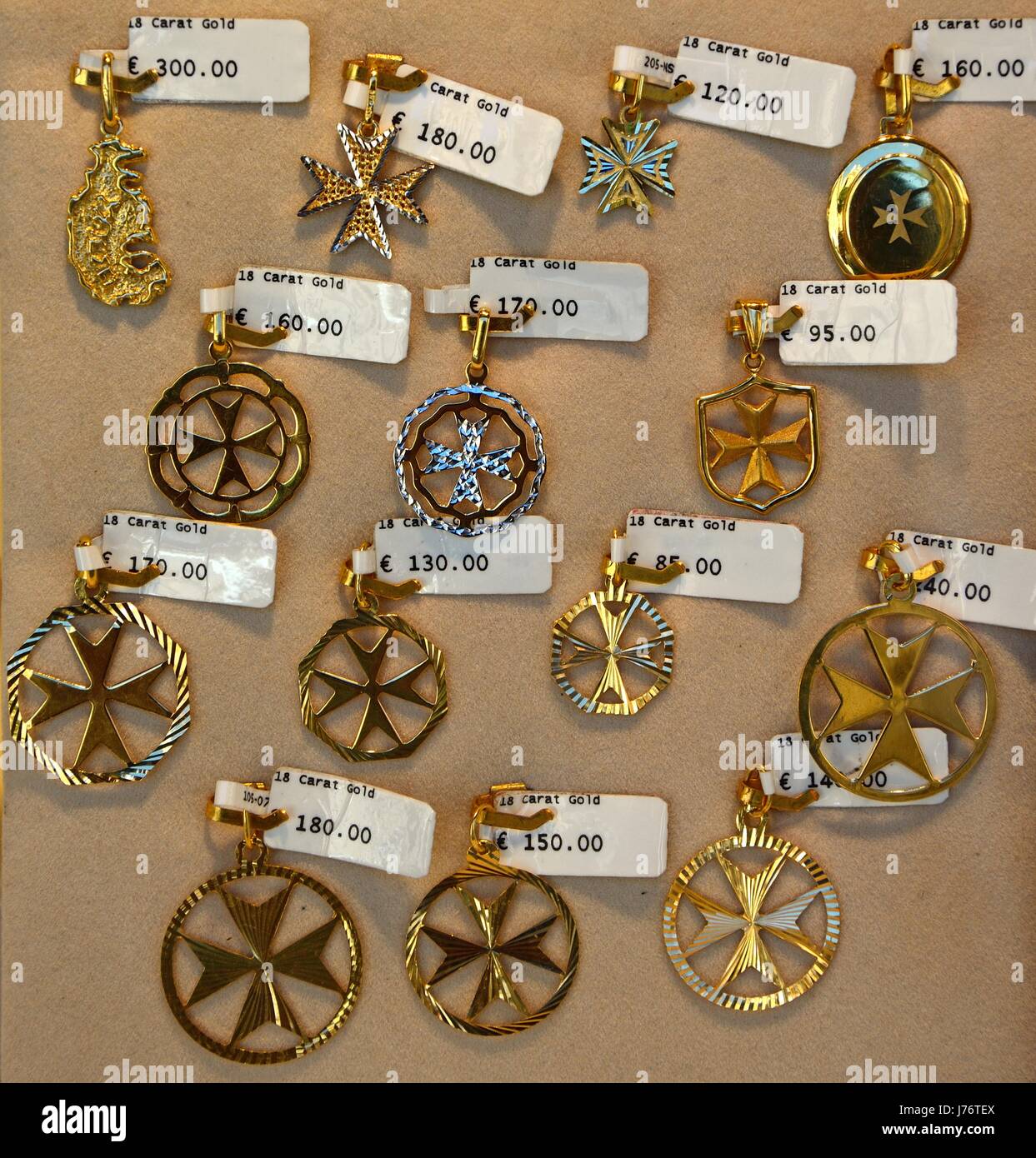 Gold Maltese cross pendants for sale in a shop along Republic Street aka Triq Ir Repubblika, Valletta, Malta, Europe. Stock Photo