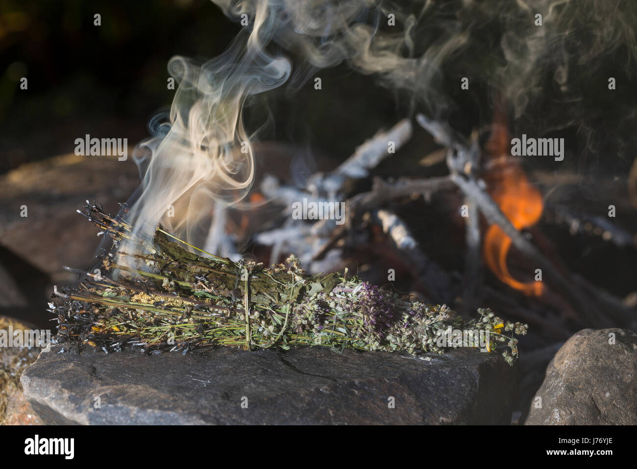 Räuchern am Lagerfeuer, Räucherbündel, Räucherbüschel, Räucherritual, Sommersonnenwende, Räuchern mit Kräutern, Kräuter verräuchern, Wildkräuter, Duft Stock Photo