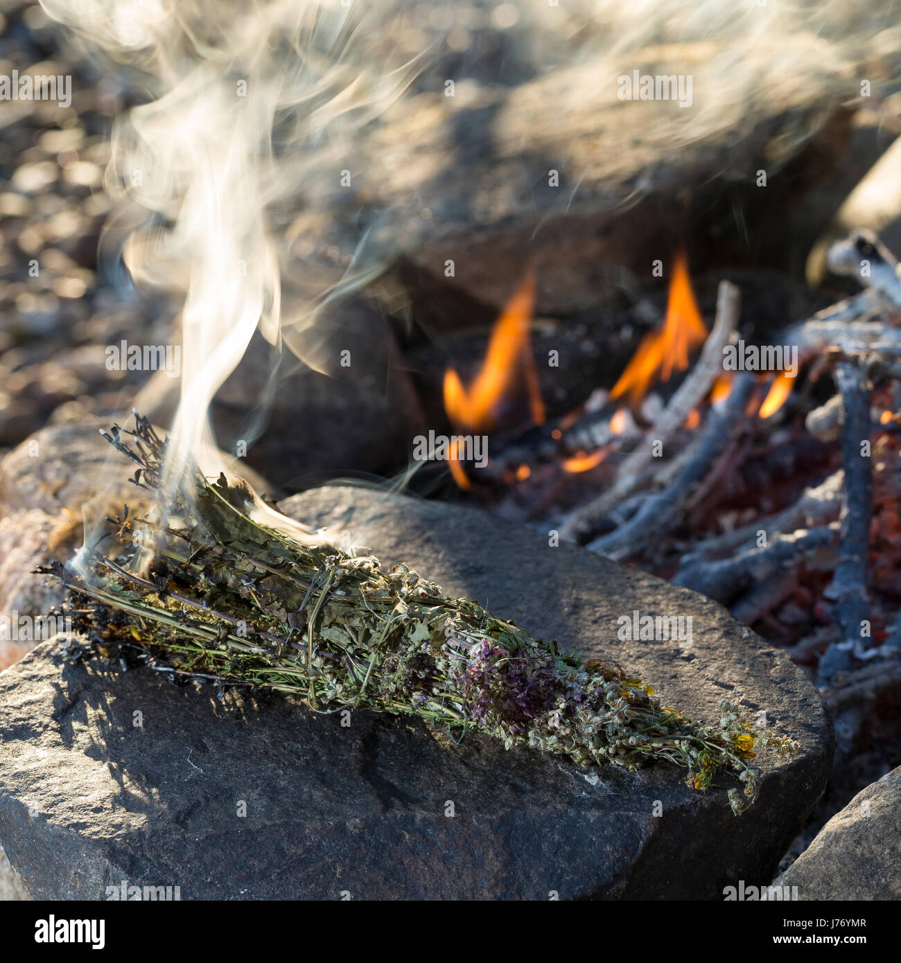 Räuchern am Lagerfeuer, Räucherbündel, Räucherbüschel, Räucherritual, Sommersonnenwende, Räuchern mit Kräutern, Kräuter verräuchern, Wildkräuter, Duft Stock Photo