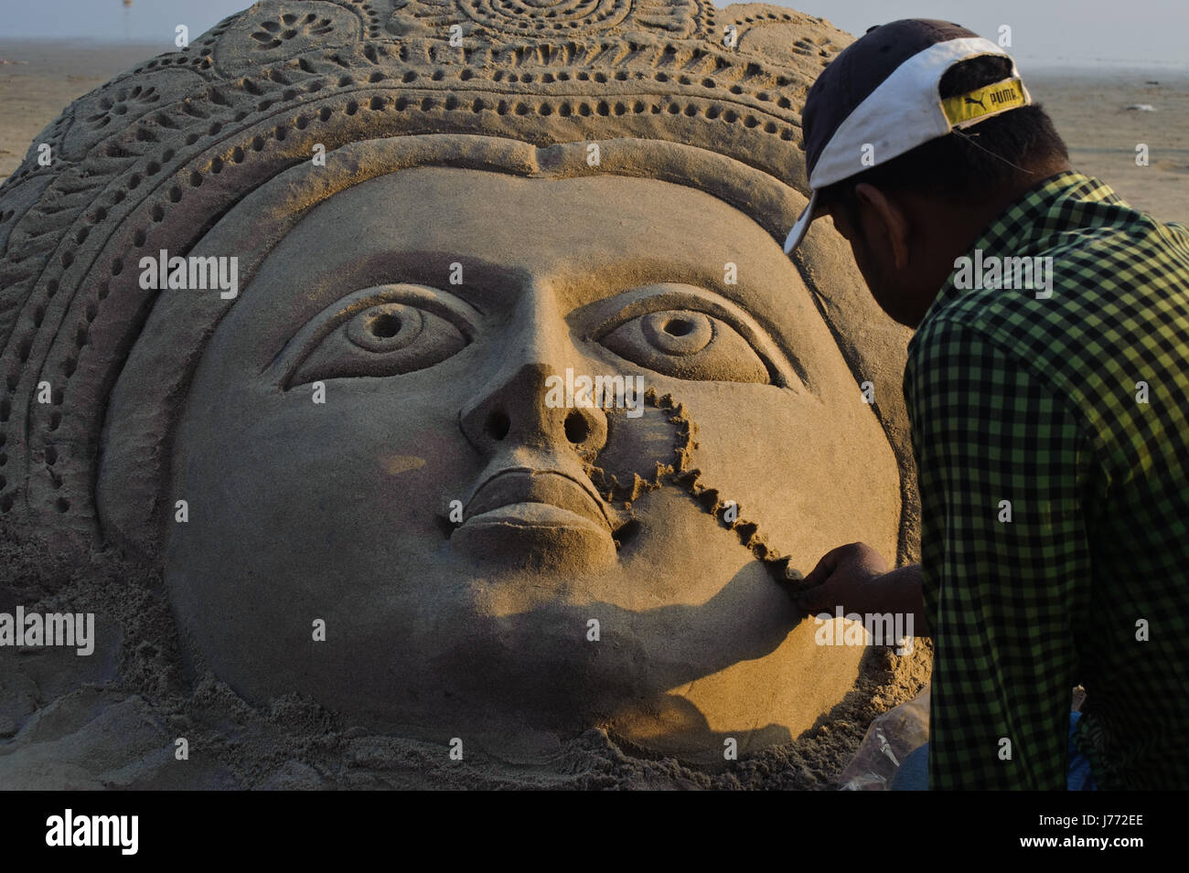 Sand artist at work ( India). The sculpture represents the hindu goddess Lakshmi. Stock Photo