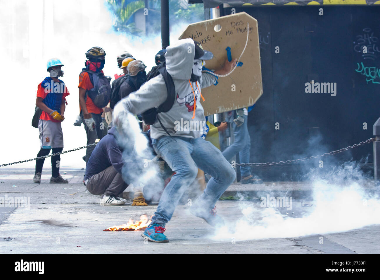 A demonstrator throws back to the police a tear gas canister during a