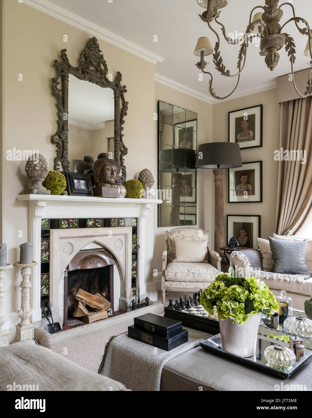 Drawing room with ottoman, chandelier and three-seater linen sofa all from Bardoe & Appel. The walls are painted in Oxford Stone estate by Farrow & Ba Stock Photo