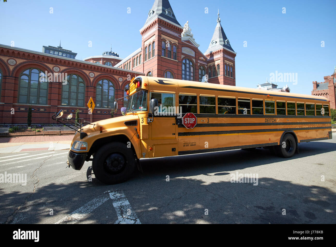 bluebird yellow school bus passing the smithsonian arts and industries building Washington DC USA Stock Photo