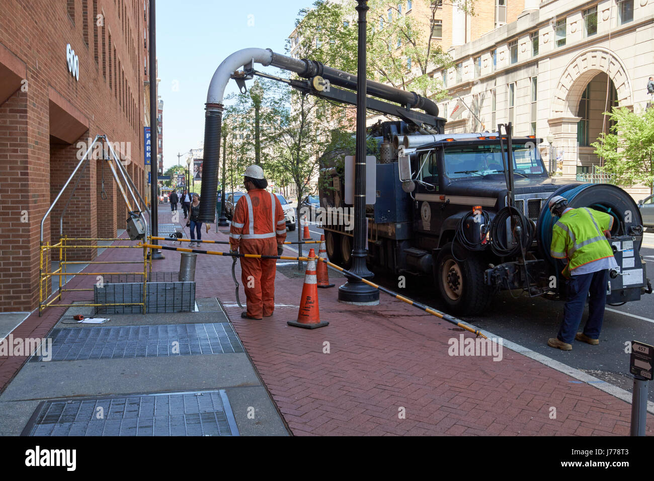 workmen using a vacuum truck to clean out sewers and liquid waste downtown Washington DC USA Stock Photo