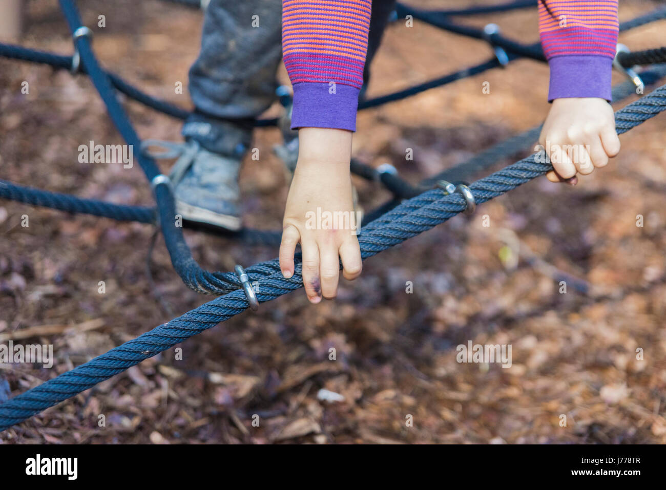 Cropped image of boy playing on jungle gym Stock Photo