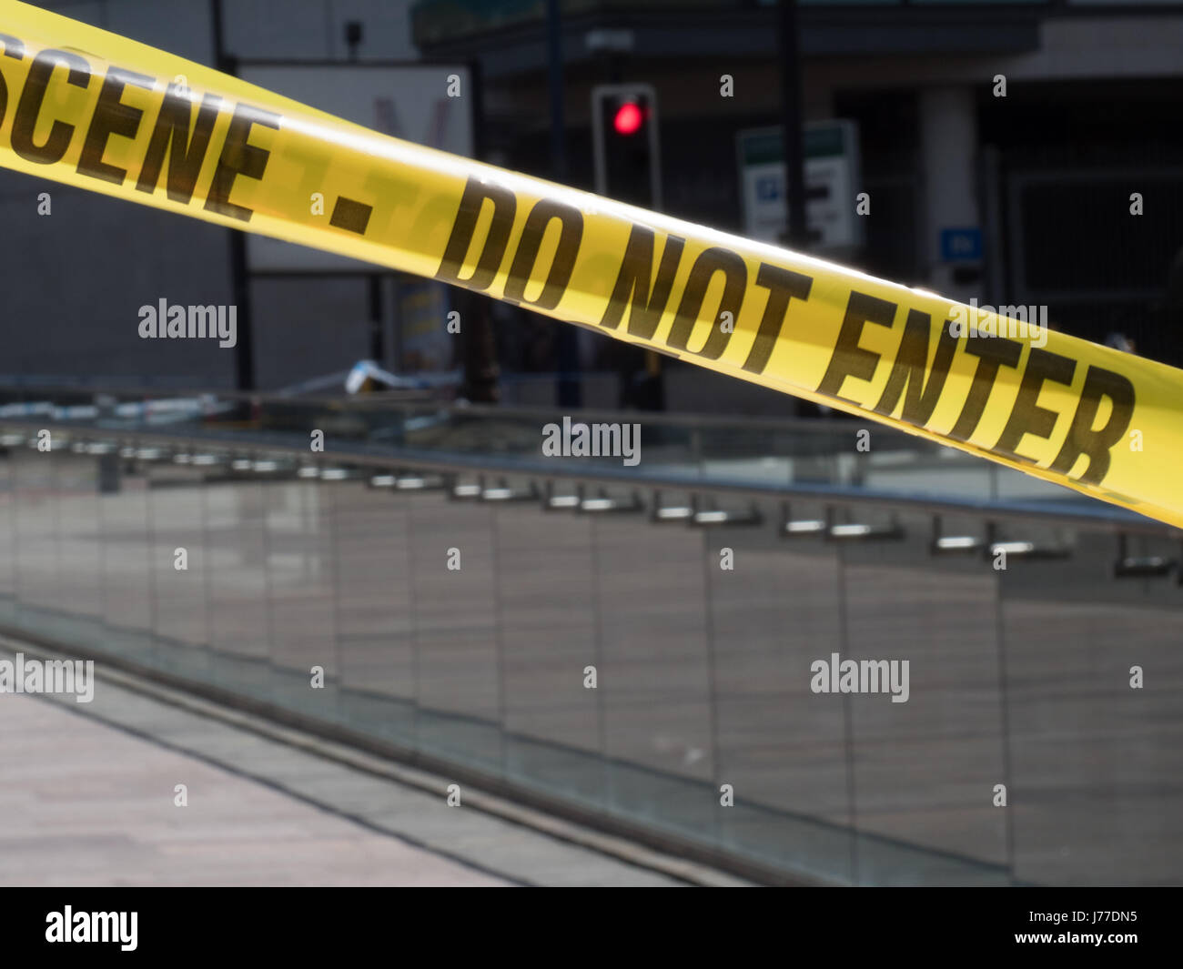 Manchester, UK. 23rd May, 2017. The police crime scene tape used as a cordon near to the Manchester Arena in Manchester city centre (with Harvey Nichols store and a City of Manchester sign visible), the day after a suicide bomb attack killed 22 as crowds were leaving the Ariana Grande concert at the Manchester Arena. Credit: Chris Rogers/Alamy Live News Stock Photo