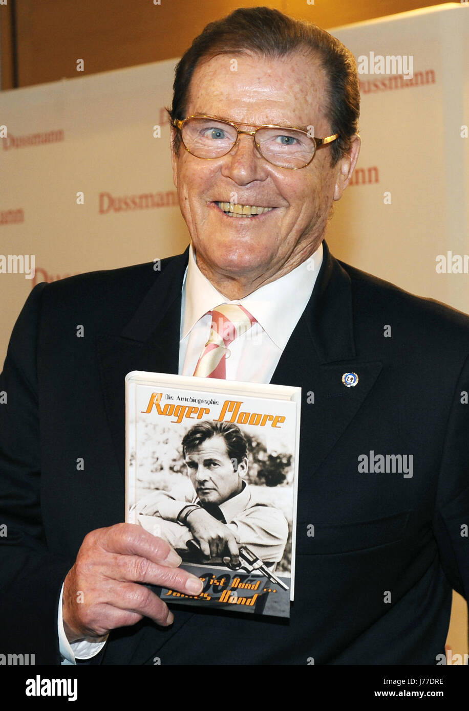 Foto di Sir Roger Moore in posa da James Bond 007 firmata 