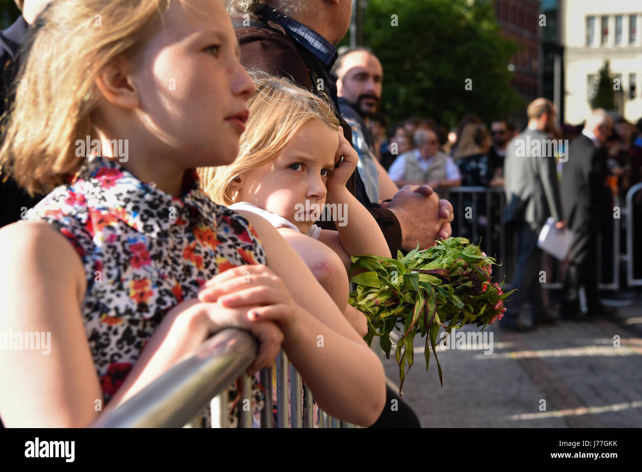Manchester, UK. 23rd May, 2017. A child holds flowers at a vigil in Manchester's Albert Square to pay respect following the terrorist attack on Manchester Stadium. Manchester Mayor Andy Burnham, Home Secretary Amber Rudd, Labour leader Jeremy Corbyn and Lib Dem leader Tim Farron, alongside city and faith leaders were amongst those who attended. Credit: Jacob Sacks-Jones/Alamy Live News. Stock Photo